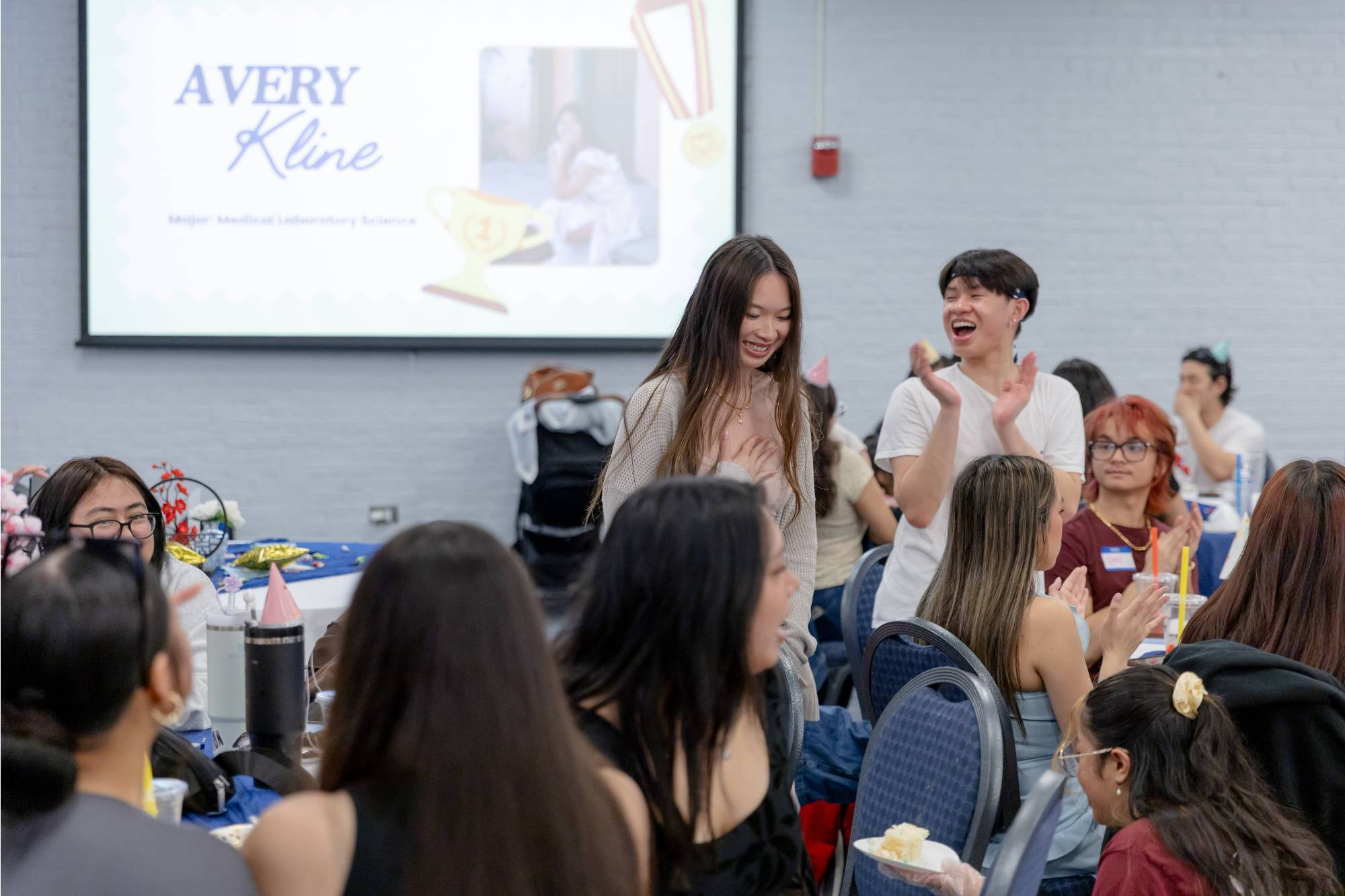 Asian Grad Celebration student walking up after her name is called
